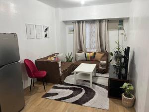 マニラにあるConvenient 2-Bedroom Condo Unit in the Metroのソファとテーブルのあるリビングルーム