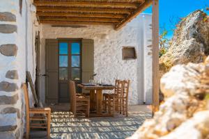 a patio with a table and chairs on a building at Sifnos Themonies in Apollonia