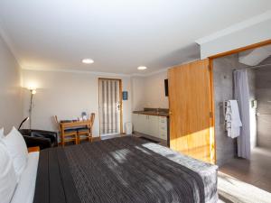 ein Hotelzimmer mit einem Bett und einem Tisch in der Unterkunft ASURE Chelsea Gateway Motor Lodge in Westport