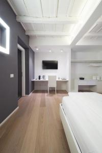 Habitación blanca con cama y escritorio. en Como Luxury Rooms, en Como