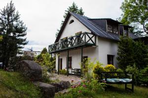 a small white house with a black roof at Młynarzowy Dworek in Gdynia