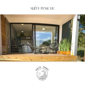 een terras met 2 stoelen en een tafel en een keuken bij VENTO TERRAL SURF STUDIOS in Imbituba