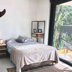 a bedroom with a bed and a large window at VENTO TERRAL SURF STUDIOS in Imbituba +54 photos