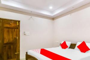 a bedroom with two beds with red pillows at OYO Flagship 81201 Sls Luxury Suites in Visakhapatnam