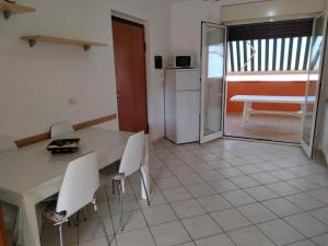 kuchnia z białym stołem i krzesłami oraz stołem w obiekcie Appartamento Solaris 200 m dal mare w mieście San Salvo