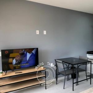 a living room with a tv and a dining table at VENTO TERRAL SURF STUDIOS in Imbituba