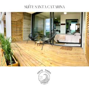 een terras met twee stoelen en een bed in een slaapkamer bij VENTO TERRAL SURF STUDIOS in Imbituba