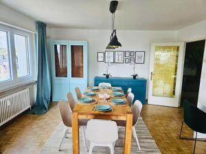 une salle à manger avec une table en bois et des chaises blanches dans l'établissement 3 bedrooms in belair with Terrace&Parking - 10, à Hollerich