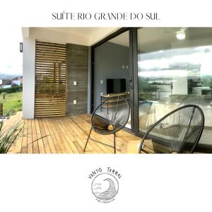 een foto van een veranda met twee stoelen op een terras bij VENTO TERRAL SURF STUDIOS in Imbituba