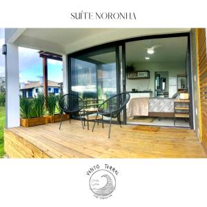 een huis met twee stoelen en een tafel op een terras bij VENTO TERRAL SURF STUDIOS in Imbituba