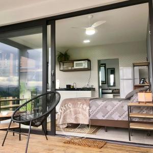a bedroom with a bed and a large window at VENTO TERRAL SURF STUDIOS in Imbituba