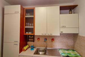 ポルト・エンペードクレにある"Stella Marina" Apt - on the coast of Agrigentoの白いキャビネットとシンクのあるキッチン