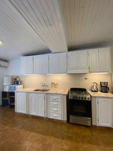 a kitchen with white cabinets and a stove at Casa 2 habitaciones en barrio céntrico in San Rafael