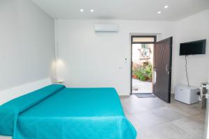 ein Schlafzimmer mit einem blauen Bett und einer Glasschiebetür in der Unterkunft Al Vicolo in Acireale