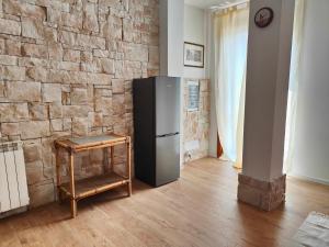 een koelkast in een kamer met een bakstenen muur bij Villa Asia in Viagrande