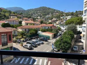 a view of a city with cars parked in a parking lot at Studio avec grand balcon - Roquebrune Cap-Martin proche Menton et Monaco in Roquebrune-Cap-Martin