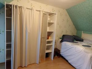 - une chambre avec un lit et un placard dans l'établissement La maison bleue, à Épluches
