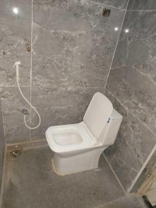 a bathroom with a toilet in a stone wall at Collection O 81233 Mr Residency in Hyderabad