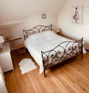 a bedroom with a bed and a wooden floor at Le Mas aux Papillons in Vendat