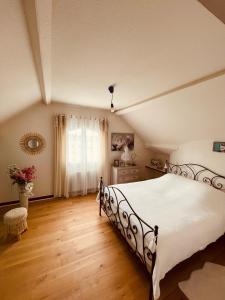 a bedroom with a large white bed and a window at Le Mas aux Papillons in Vendat