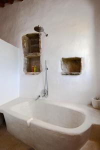 eine Badewanne in einem Zimmer mit einem Vogel an der Wand in der Unterkunft Sifnos Themonies in Apollonia