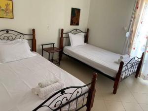 two beds in a room with white sheets at Beach View Siviri in Siviri