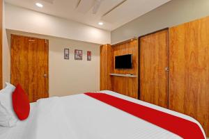 a bedroom with a bed and wooden cabinets at OYO Flagship Hotel Reet Villa in Ahmedabad
