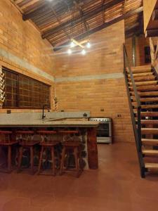 een keuken met een tafel, een wastafel en een trap bij Casa del Rio in the Andes in Gualaceo