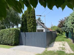 a blue fence in front of a house at Nóra Apartman in Balatonkenese