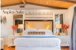 a bedroom with a large white bed with a wooden headboard at Villa Inn- Adults Only- Temecula Wine Country in Temecula
