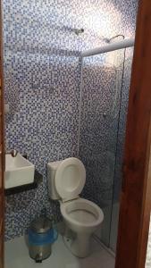 a bathroom with a toilet and a shower and a sink at Pousada Farol da Barra in Tutóia
