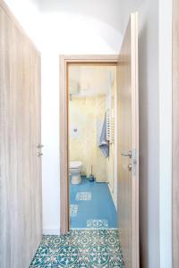 La salle de bains est pourvue de toilettes et d'un sol bleu. dans l'établissement Dipinto di Blu by PortofinoVacanze, à Rapallo