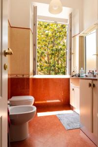a bathroom with a toilet and a large window at Luxury Borghese Magnolia Suite in Rome