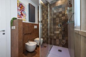 La salle de bains est pourvue de toilettes et d'une douche en verre. dans l'établissement VISCONTI 46 Central Apartments, à Bari