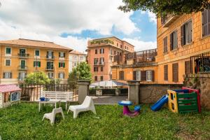 eine Gruppe von Stühlen im Gras vor Gebäuden in der Unterkunft Luxury Borghese Magnolia Suite in Rom