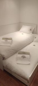 two beds with white sheets and towels on them at Gerês VillaCella in Vieira do Minho +17 photos