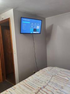 een flatscreen-tv aan de muur van een slaapkamer bij private upper 1 bd apartment in Buffalo
