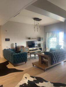 ein Wohnzimmer mit 2 blauen Sofas und einem Tisch in der Unterkunft Luxury Flat for Embassies & GM in Ankara
