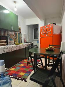 eine Küche mit einem Tisch und einem roten Kühlschrank in der Unterkunft A sweet house for families, in Üsküdar in Istanbul