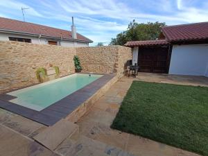 a backyard with a swimming pool and a stone wall at MIRADOR DEL HITO I y MIRADOR DEL HITO II in Espinosa de Bricia