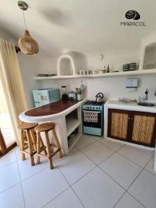 a kitchen with a table and chairs and a stove at Maracol Bungalows Vichayito in Vichayito