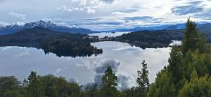 widok na jezioro z drzewami i górami w obiekcie Posada del Ñireco w mieście Bariloche