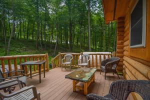 a wooden deck with chairs and tables on a cabin at Big Log Lodge in McHenry