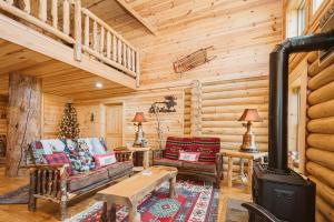 a log cabin living room with a wood stove at Big Log Lodge in McHenry +64 photos