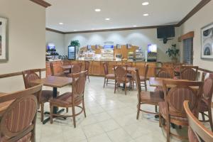 ein Restaurant mit Holztischen und -stühlen und einer Theke in der Unterkunft Holiday Inn Express Evansville - West, an IHG Hotel in Evansville