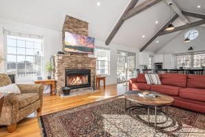 a living room with a red couch and a fireplace at Stilwater Serenity in Swanton
