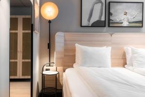 オスロにあるスカンディック オスロ シティの白いベッド1台、壁に2枚の写真が飾られたベッドルーム1室