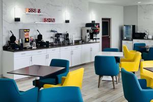 甘斯拜的住宿－Comfort Suites Denver North - Westminster，一间设有黄色和蓝色椅子和桌子的等候室