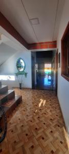 a living room with a wooden floor and a hallway at Casa Hotel los Patios in Jericó