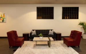 a living room with a couch and two chairs at Clarion Hotel New Orleans - Airport & Conference Center in Kenner